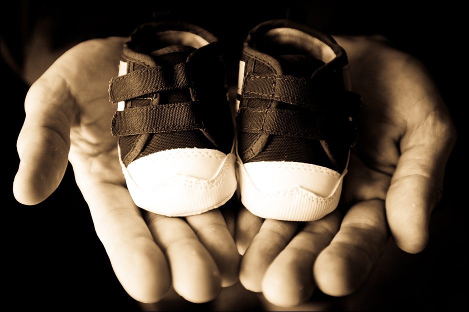 dad holding baby shoes