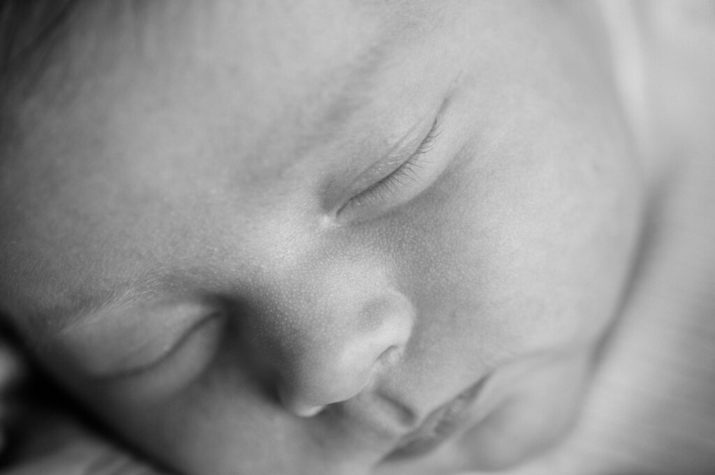 Black and white image of close up of newborn baby's face
