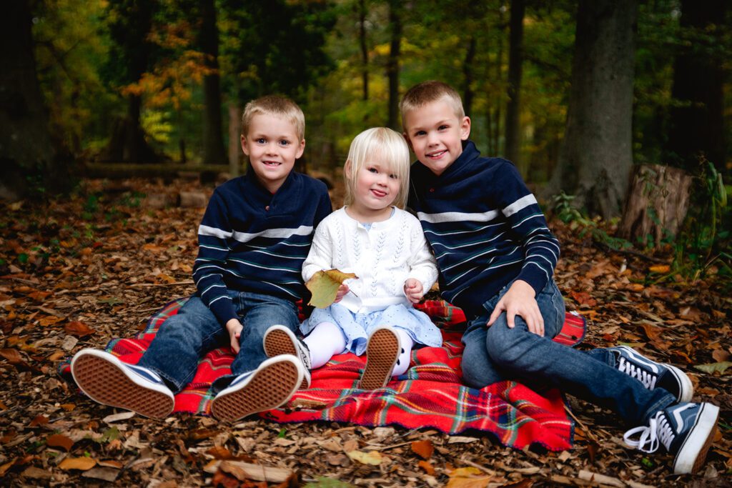 Fun family photo with three kids in a park.