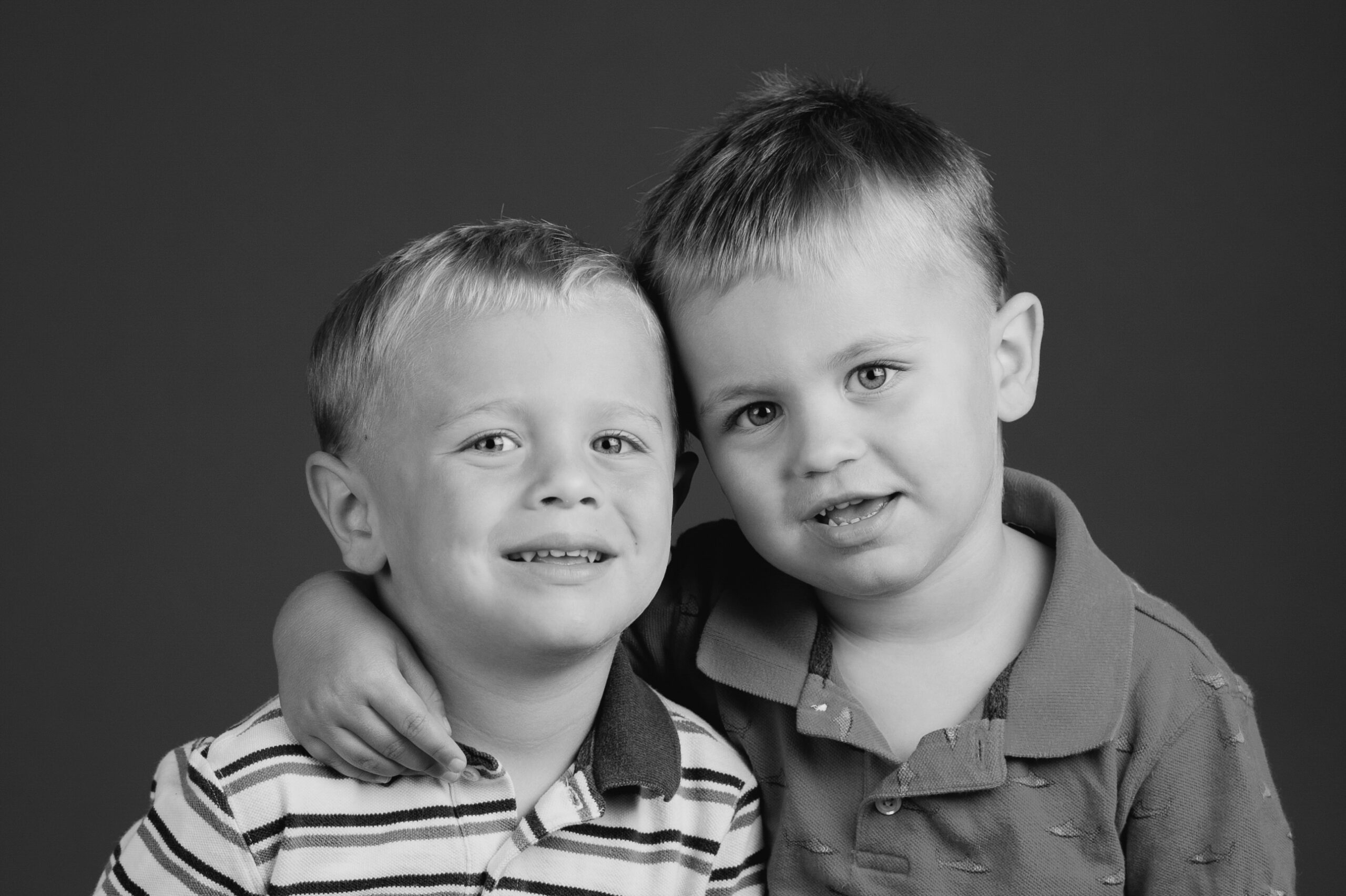 brothers smiling together for a portrait in black and white